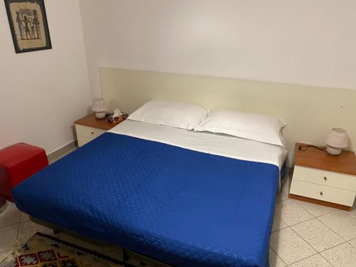 Una cama azul y blanca en una habitación en Case vacanze Dalia, en Torregrotta