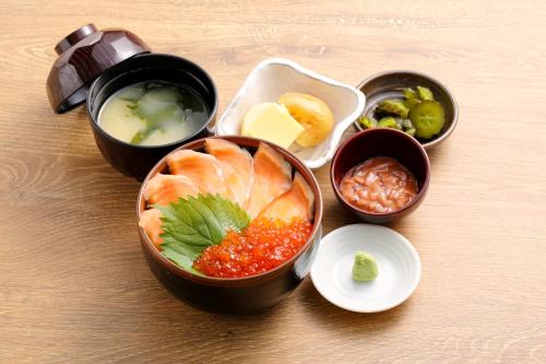 a table with bowls of food on a table at Richmond Hotel Sapporo Ekimae in Sapporo
