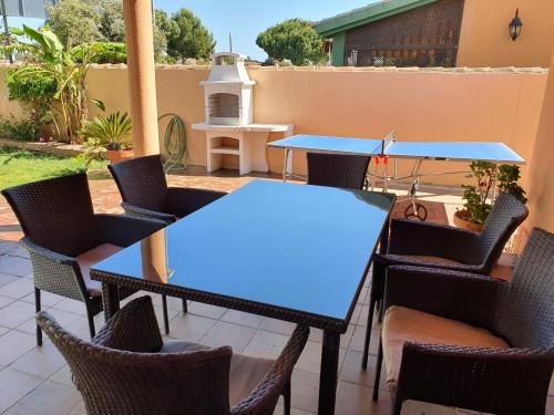 a patio with blue tables and chairs and a grill at Villa Ostrero in Chiclana de la Frontera