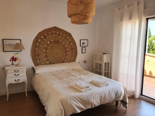 a bedroom with a bed with towels on it at Villa Ostrero in Chiclana de la Frontera