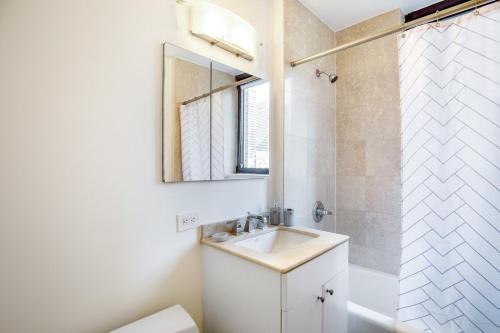 a bathroom with a sink and a mirror and a shower at 1BR nr Times Sq w Indoor pool Gym NYC-141 in New York