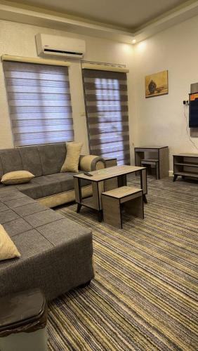 een woonkamer met een bank en een tafel bij اوركيدا الشمال للشقق الفندقية in Al Mafraq