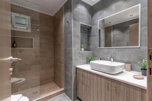 a bathroom with a white sink and a shower at Aurora Apartment, Room 2 - Cozy, close to the beach in Marmari