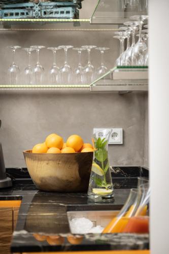 a bowl of oranges on a counter with wine glasses at Hotel Donauhof in Deggendorf