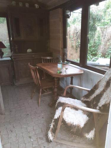 - une table et des chaises dans une chambre avec fenêtre dans l'établissement Bauernhof-Offene Gartenhütte Grüne Oase Schlafsack, à Hausbreitenbach