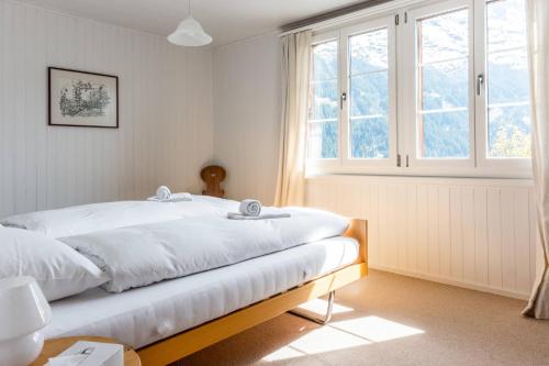 - une chambre avec un lit et une grande fenêtre dans l'établissement Chalet Lienzhubel - GRIWA RENT AG, à Grindelwald