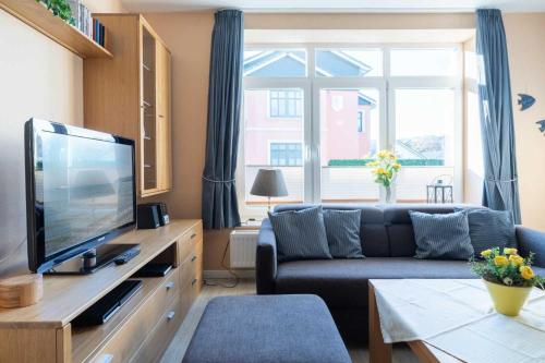 a living room with a couch and a television at Villa Marin Wohnung 02 in Zinnowitz