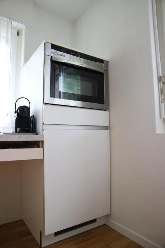 a microwave oven sitting on top of a white refrigerator at Studio CHic in Niederweningen