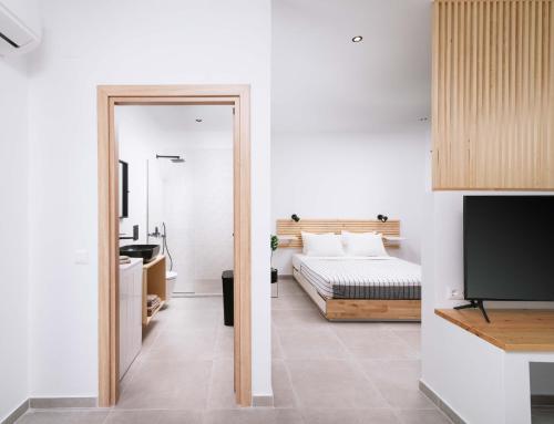 ein Schlafzimmer mit einem Bett und einem TV in einem Zimmer in der Unterkunft Euphoria Luxury Apartment in Matala
