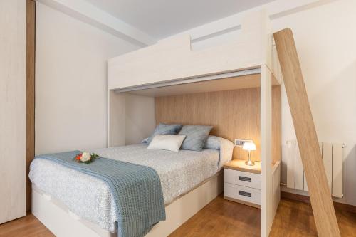 ein kleines Schlafzimmer mit einem Etagenbett mit einer Leiter in der Unterkunft Armonia estudio, comparte exterior in Llinars del Vallès