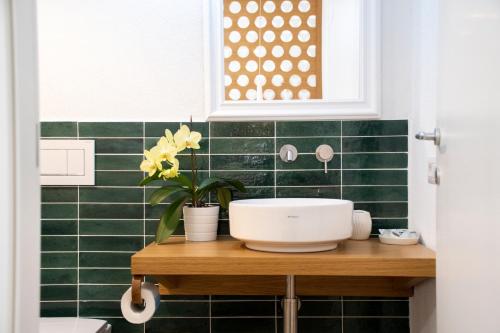 baño con paredes de azulejos verdes y lavabo en Taonasi Taormina City Apartment, en Taormina