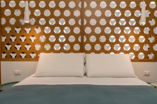 Un dormitorio con una pared con almohadas blancas en una cama en Taonasi Taormina City Apartment, en Taormina