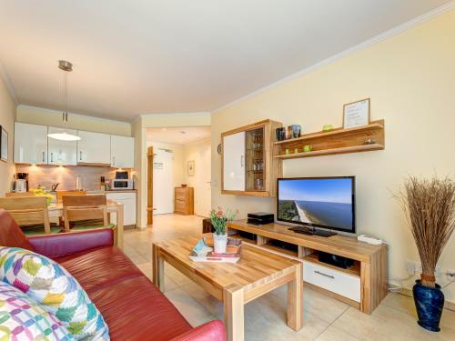 ein Wohnzimmer mit einem Sofa und einem TV in der Unterkunft Residenz am Balmer See - BS 36 mit Wellnessbereich in Balm