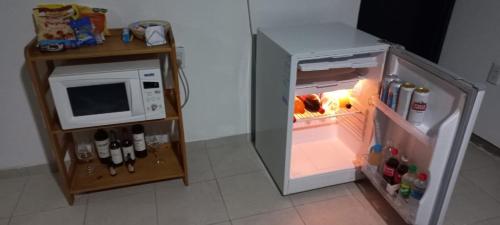 a small refrigerator with its door open next to a microwave at Apartamentos Willy - en Zona Residencial con Estacionamiento in Mendoza