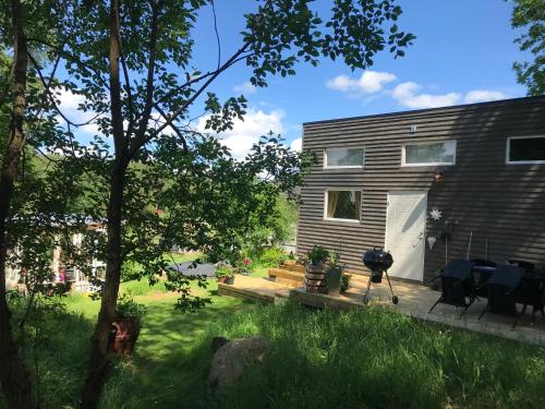 a backyard of a house with a grill and a patio at 15 min från Ullared! Ny stuga med hög standard! in Älvsered