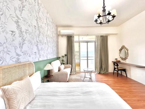 a bedroom with a bed and a living room at 永安101 Wing on x 附陽台 in Taitung City