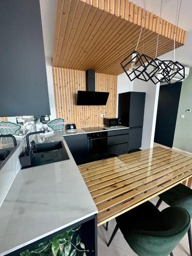 a kitchen with a wooden table and a sink at Luxusný apartmán na 21 poschodí s parkovaním zadarmo BA in Bratislava