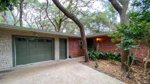 een stenen huis met een garage en een boom bij VERY NICE COTTAGE home in Jekyll Island