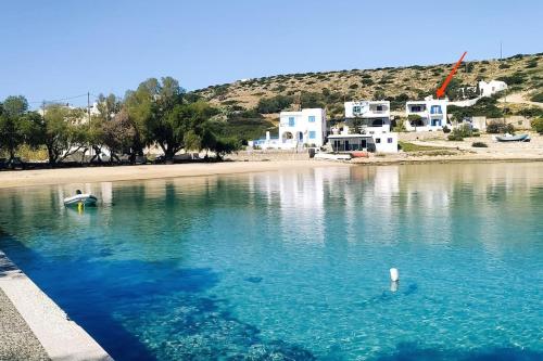 a large body of water with a beach and houses at Thalassa house by the sea in Áyios Yeóryios