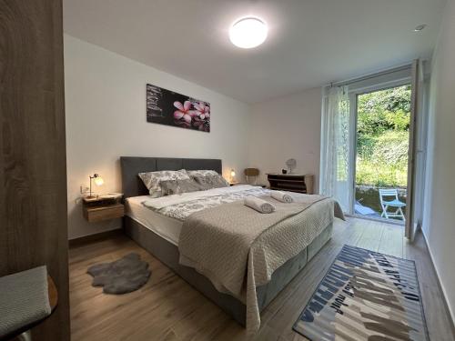 een slaapkamer met een bed en een groot raam bij Apartment Toni in Lovran