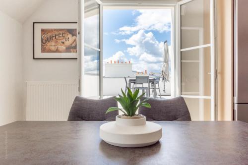 a table with a plant sitting on top of it at Sur un Nuage by Plaza in Serris