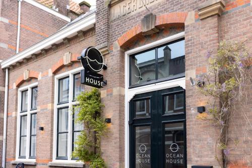 un bâtiment en briques avec un panneau indiquant une maison dans l'établissement Ocean House Scheveningen, à Scheveningen