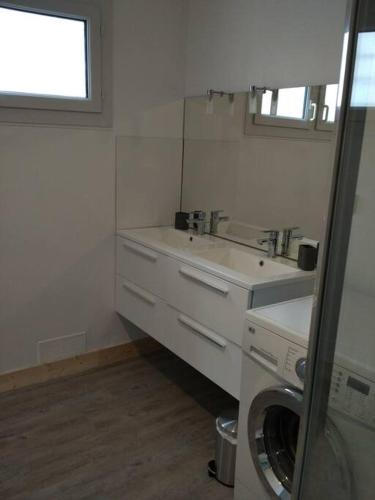 une salle de bain avec un lavabo et une machine à laver dans l'établissement L'emeraude : Ares, House, 3 bedrooms, à Arès