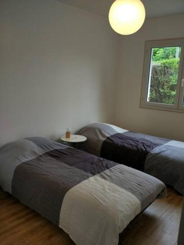 - 2 lits dans une chambre avec une fenêtre et une table dans l'établissement L'emeraude : Ares, House, 3 bedrooms, à Arès