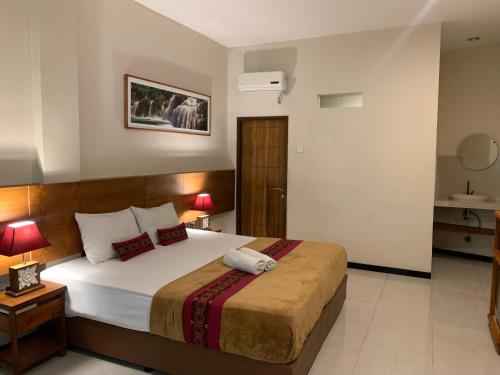 a bedroom with a large bed in a room at Kuta Suci Guesthouse in Kuta
