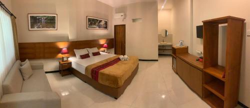 a hotel room with a bed and a bathroom at Kuta Suci Guesthouse in Kuta