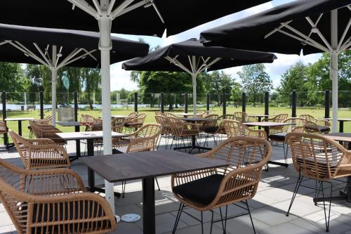 a group of tables and chairs with umbrellas at Hotel Norden in Haderslev