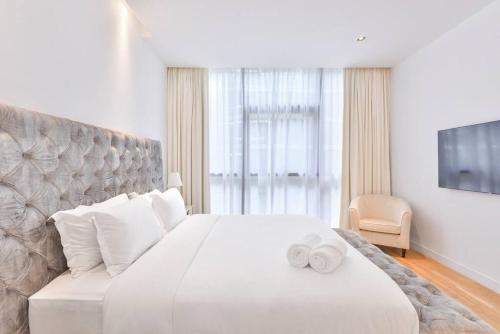 a bedroom with a large white bed with two white towels on it at NEW! Luxurious 3 bedroom apartment in City Walk in Dubai