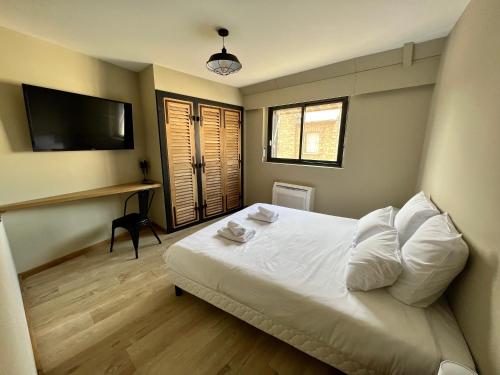 a bedroom with a bed and a desk and a television at Le Loft Manhattan, en centre ville, proche Sainte Bernadette avec Parking in Nevers
