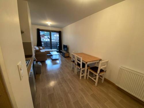 a living room with a table and chairs and a couch at Appartement très cosy en plein centre in Les Gets