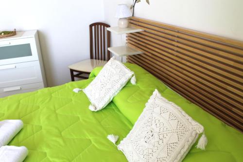 a green bed with two pillows on top of it at Vent In Costa Ospitalità Diffusa in Furore