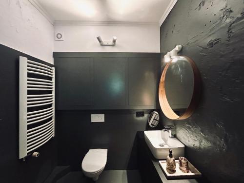 a bathroom with a toilet and a sink and a mirror at Apartament Centrum A in Wejherowo