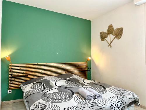 een slaapkamer met een bed en een groene muur bij COC - La Belle Etoile in Wissant