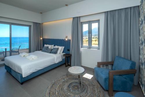 a hotel room with a bed and a chair at Mochlos Blue in Mochlos