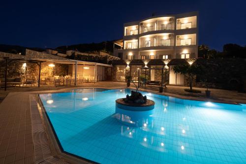 a swimming pool in front of a hotel at night at Mochlos Blue in Mochlos