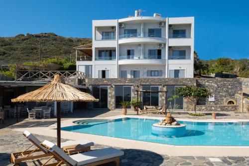 a hotel with a swimming pool in front of a building at Mochlos Blue in Mochlos