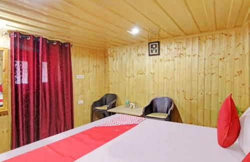 a bedroom with a bed and a desk and chairs at Deodar Homestay Dakbangla-kufri in Shimla