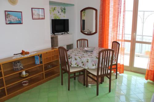 a dining room with a table and chairs and a television at Vent In Costa Ospitalità Diffusa in Furore