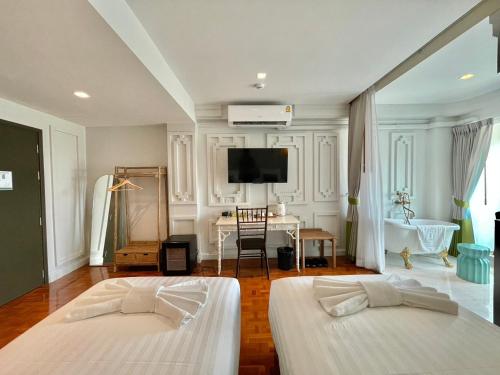 two beds in a room with a tv on the wall at Wiang Ville Boutique Hotel in Chiang Mai