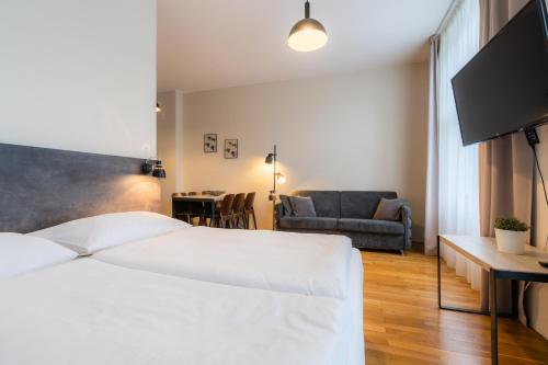 sypialnia z dużym białym łóżkiem i kanapą w obiekcie EA ApartHotel Melantrich w Pradze