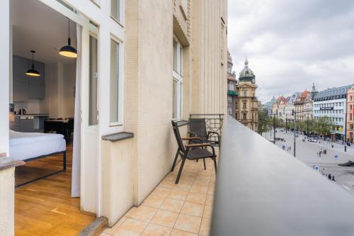 a balcony with a bed and a view of a city at EA ApartHotel Melantrich in Prague