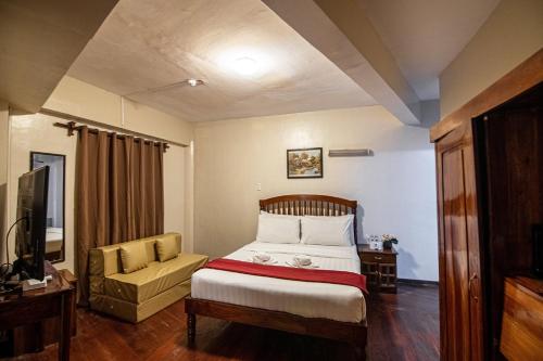 sypialnia z łóżkiem, kanapą i telewizorem w obiekcie Kiwi Hotel w Cebu