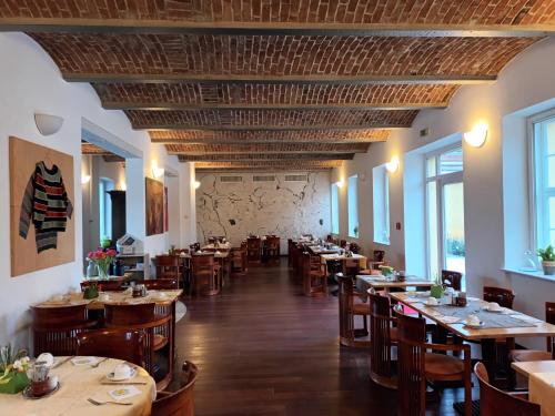 Hotel Vierseithof Luckenwalde في لوكنفالده: غرفة طعام مع طاولات وكراسي خشبية