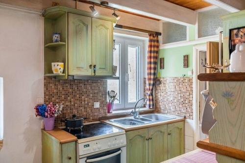 una cucina con armadi verdi e lavandino di Steffi's Place,Corfu Old Town a Città di Corfù
