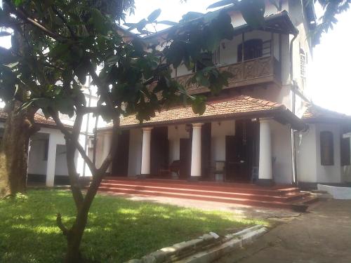 a building with a tree in front of it at College House Close to Fort in Colombo