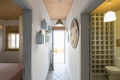 bagno con servizi igienici e parete in vetro. di Casa da Avó ad Alcácer do Sal